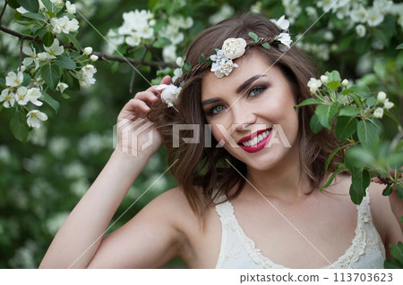 brunette lady outdoor portrait. Healthy woman against green blossom background brunette lady outdoor portrait. Healthy woman against green blossom background 113703623