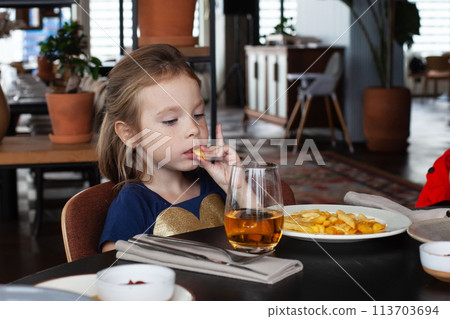 Little girl enjoying dinner at the restaurant Little girl enjoying dinner at the restaurant 113703694