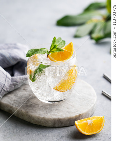 Lemonade tonic drink with fresh lemon, mint and ice on a marble board on a  light background  113703778
