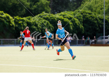 Young field hockey player run on the pitch in attack 113703830