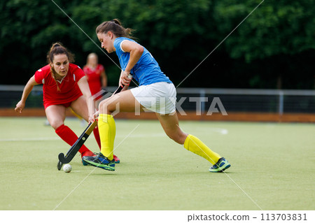 Young field hockey player leading the ball in attack 113703831