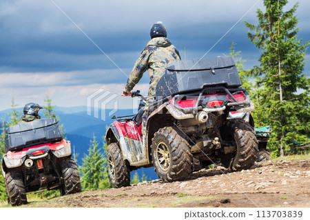 Tourist on ATV driving through the mountains 113703839