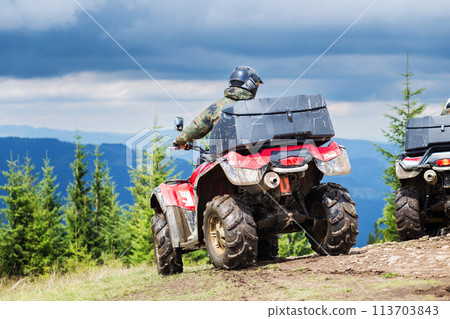 Tourist on ATV driving through the mountains 113703843