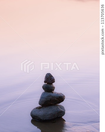 Stones (pebbles) stacked on top of each other - rockbalance. Gentle sunset colors. Stones (pebbles) stacked on top of each other - rockbalance. Gentle sunset colors. 113705636