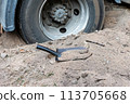 Truck  wheel is stuck in the sand. Shovel nearby. 113705668