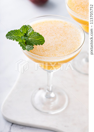 Frozen peach margaritas in three glasses with mint 113705752