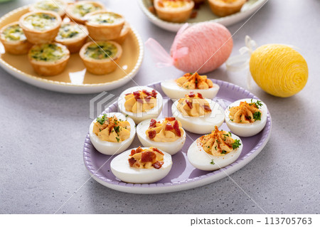 Deviled eggs and mini quiches, appetizers for Easter 113705763