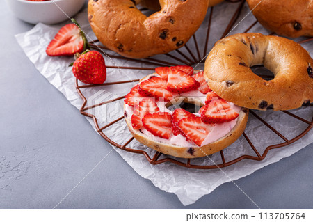 Variety of bagels served with strawberry cream chees and fresh berries 113705764