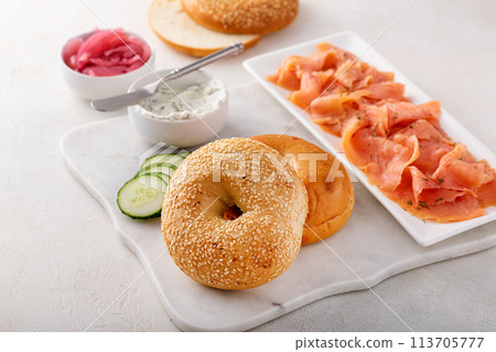 Freshly baked bagels served with dill cream cheese and salmon Freshly baked bagels served with dill cream cheese and salmon 113705777