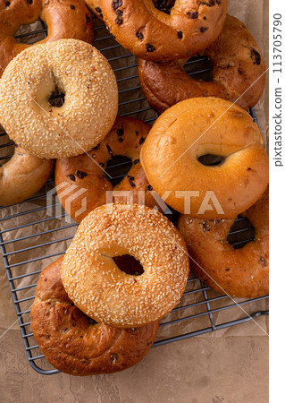 Variety of freshly baked bagels on a cooling rack 113705790