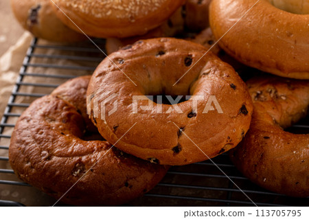 Variety of freshly baked bagels on a cooling rack 113705795