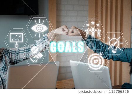 Goals concept, Young business people pump hands on office workspace with vision, plan, support, success, innovation and goals icon on virtual screen. 113706236