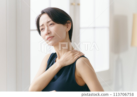 A woman in her 30s suffering from stiff shoulders A woman in her 30s suffering from stiff shoulders 113706758