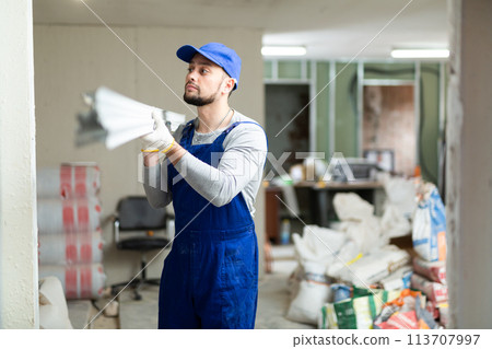Worker carrying construction materials at renovating object Worker carrying construction materials at renovating object 113707997