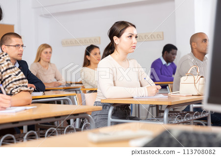 Young woman studying with colleagues at classroom Young woman studying with colleagues at classroom 113708082