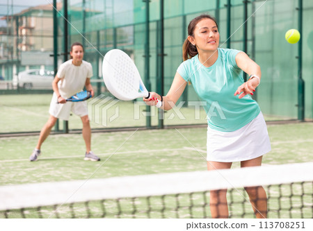 Two sports women playing padel on tennis court Two sports women playing padel on tennis court 113708251