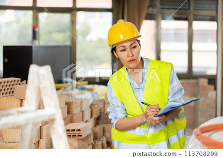 Woman making notes on indoor construction site Woman making notes on indoor construction site 113708299