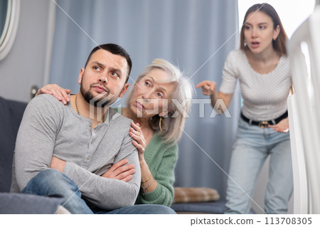 Elderly mother comforts her son after his quarrel with his wife Elderly mother comforts her son after his quarrel with his wife 113708305