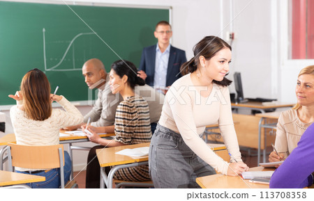 Adult students discussing learning material in small groups 113708358
