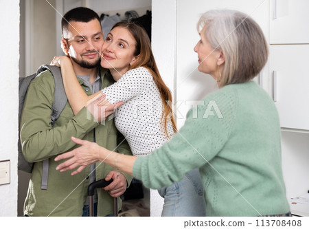 Woman and her mother welcoming man at home 113708408