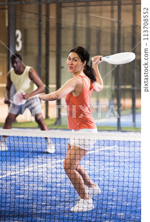 Young asian woman playing padel on a hard court 113708552