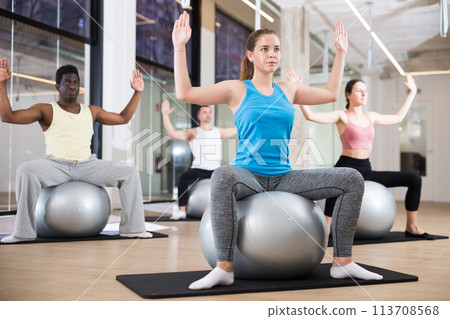 Sporty people training pilates at group class Sporty people training pilates at group class 113708568