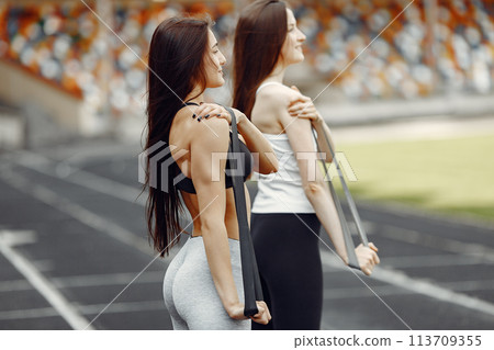 Beautiful girls at the stadium. Sports girls in a sportswear. People use a eraser. Beautiful girls at the stadium. Sports girls in a sportswear. People use a eraser. 113709355