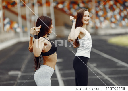 Beautiful girls at the stadium. Sports girls in a sportswear. People use a eraser. Beautiful girls at the stadium. Sports girls in a sportswear. People use a eraser. 113709356