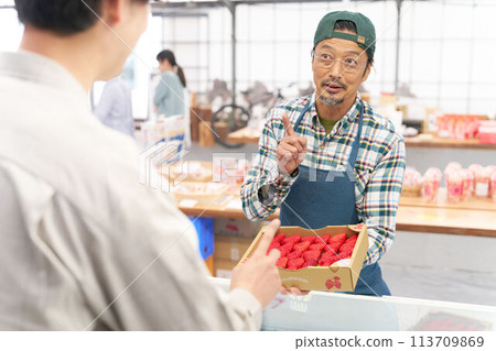 Male staff selling strawberries at the store Male staff selling strawberries at the store 113709869