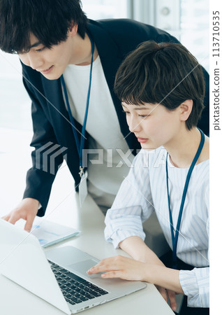 Young men and women operating computers in the office Young men and women operating computers in the office 113710535