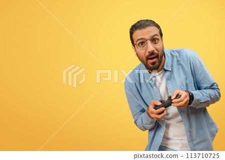 Man surprised playing with game controller Man surprised playing with game controller 113710725