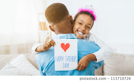 Little girl hugging dad and giving him postcard 113710726