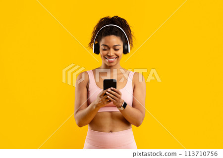 Young african american woman enjoying music on phone 113710756