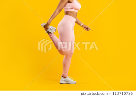 Active woman stretching leg in pink sportswear 113710786