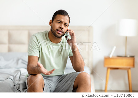 Black man talking on phone with confused look Black man talking on phone with confused look 113710805