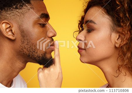 Profile of mysterious woman touching male lips with finger Profile of mysterious woman touching male lips with finger 113710806