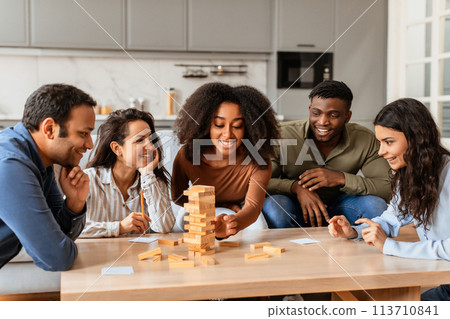 Young friends playing a block-stacking game at home Young friends playing a block-stacking game at home 113710841