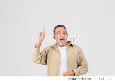 Excited senior pointing upwards on white background Excited senior pointing upwards on white background 113710909