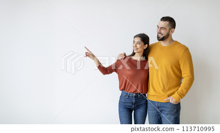 Happy couple looking and pointing Happy couple looking and pointing 113710995