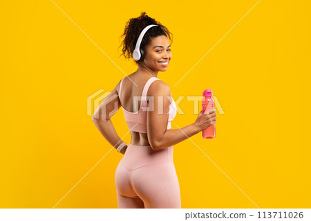 Happy fit african american woman with water bottle and headphones Happy fit african american woman with water bottle and headphones 113711026