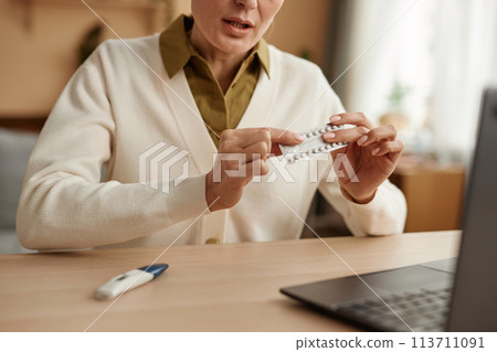 Close up of female obgyn holding blister of birth control pills consulting client online via video chat copy space 113711091
