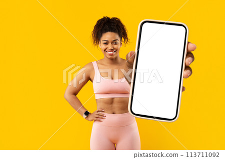Smiling african american woman showing smartphone screen 113711092