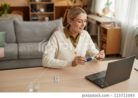 High angle portrait of smiling adult woman showing positive pregnancy test to friends and family via video chat and sharing good news copy space High angle portrait of smiling adult woman showing positive pregnancy test to friends and family via video chat and sharing good news copy space 113711093
