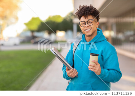 Smiling student holding coffee and binders 113711129