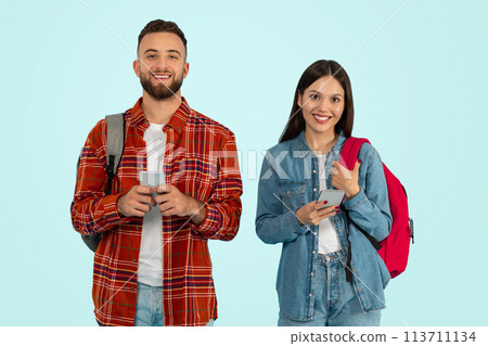 Boyfriend and girlfriend college students using cell phones, blue background 113711134