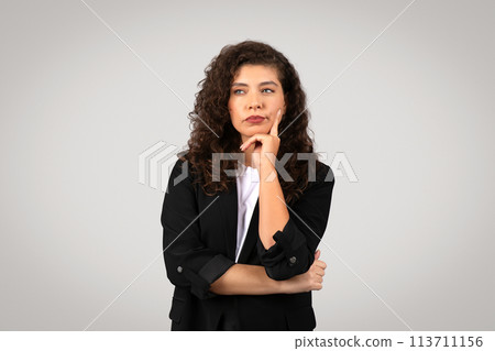 Thoughtful businesswoman with chin on hand 113711156