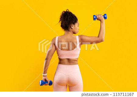 Strong woman exercising with weights, back pose 113711167