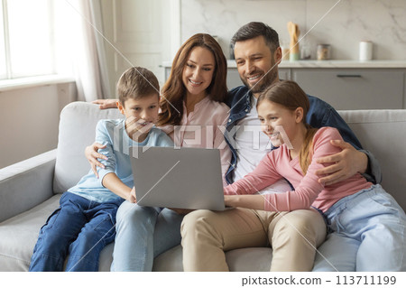 Cheerful young family with kids having fun with laptop at home Cheerful young family with kids having fun with laptop at home 113711199