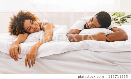 Couple sleeping back to back in bed 113711215