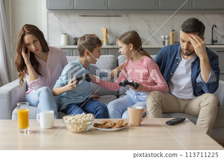 Siblings' disagreement during video game play, home interior Siblings' disagreement during video game play, home interior 113711225